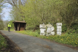 Aartalradweg with Yolo sculpture by G. von Rosenthal, cycle path, cyclist, refuge, inscription,
