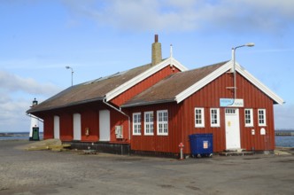 Red wooden house containing customs office in the harbor of Assens, Funen island, Denmark,