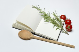 Blank notebook for cooking recipes, cooking spoon with rosemary sprig, tomato