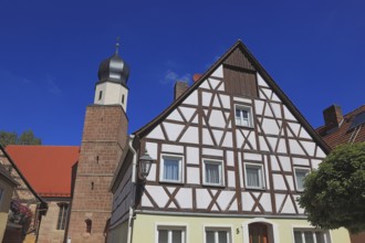 Half-timbered house and tower of the Catholic Church, town of Heideck in the district of Roth,