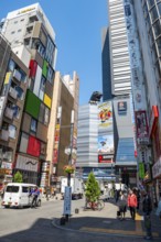 Street scene with skyscrapers, figure Godzilla head on a skyscraper, Shinjuku City, Tokyo, Japan