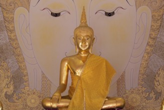 Golden Buddha statue with tunic, Bhumispara mudra, Buddha Gautama at the moment of enlightenment,