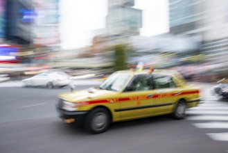 Elderly yellow taxi driving, motion blur, long exposure, Shubuya Crossing, Shibuya, Tokyo, Japan