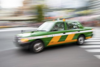 Green taxi driving, motion blur, long exposure, Shubuya Crossing, Shibuya, Tokyo, Japan