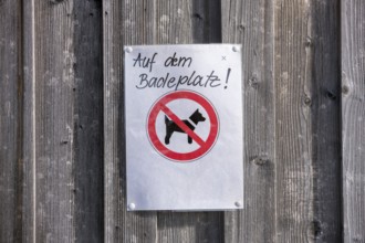 A sign on a wooden wall prohibits dogs from staying at the bathing area, near Roßhaupten,