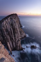 Totem Pole Long exposure at sunrise shows glowing dawn over the dramatic cliffs of Cape Hauy. Waves