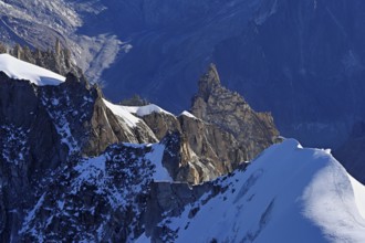 Rugged rocks jut out of a snow-covered mountain, viewing platform, Aiguille du Midi mountain