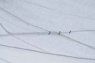 A group of mountaineers runs across a snow-covered mountain, Aiguille du Midi, Chamonix-Mont-Blanc,