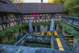 Courtyard with fishing pond of a historic inn, Rockenbrunn, Franconia, Bavaria, Germany