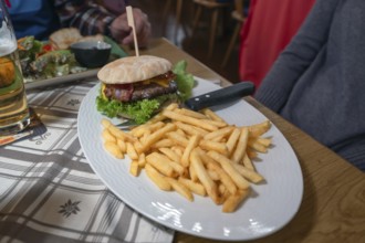 Burger, minced meat with grilled ham and French fries served in an inn, Franconia, Bavaria, Germany