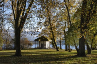 The Mettnaupark, surrounded by autumn vegetation, with the certificate house on the banks of Lake
