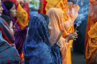 Hindu devotees gather on the banks of the Brahmaputra River to offer prayers to the Sun God on the