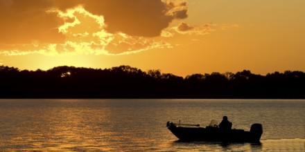 A boat on Lake Gudelack at sunset, Lindow (Mark), Stechlin-Ruppiner Land nature park Park,