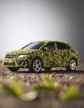Car formed by green leaves and branches. Sustainable Car technology, ecology concept in harmony