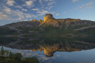Morning dream over the quiet Steigtindvatnet near Bodø. Pine forest on the rock face at sunrise