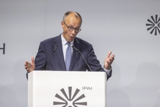 Federal Chancellor Friedrich Merz (CDU) . Portrait at the lectern with free text space.