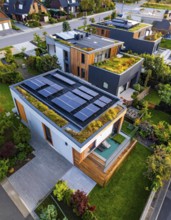 Aerial view showcases modern houses with solar panels and green roofs in a suburban setting,