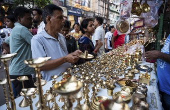 People shop for bronze and other metal items at a roadside stall on Dhanteras, in Guwahati, Assam,