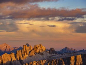 Alpine glow, rugged Dolomite peaks at sunset, colored clouds above, Dolomites, Alps, Belluno