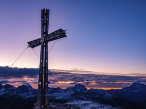 Sassongher summit cross at dawn, in the background Monte Cristallo, Monte Pelmo and Civatta,