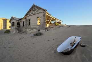 Bathtub in the sand in front of a former dwelling house, Kolmanskop, restricted diamond area, Karas