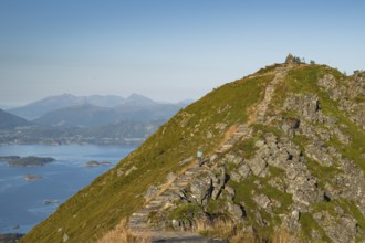 Woman with hiking poles walking up Rørsethornet stone stairs, with 3292 steps one of the longest