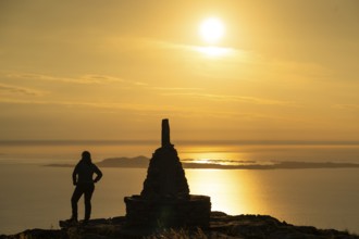 Woman standing next to cairn and looking at the sea, Rørsethornet stone staircase, with 3292 steps