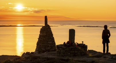 Silhouette of a woman watching the sunset next to cairns, Rørsethornet stone staircase, with 3292
