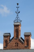 Iron ornamental element on roof peak, brick gable, former paper mill for the production of