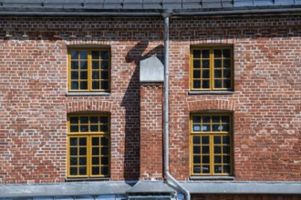 Brick façade with yellow window frames, former paper factory and mill for the production of