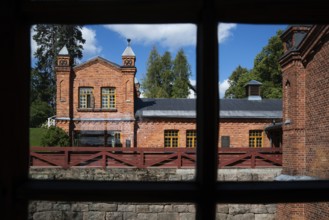 View through window frames, brick building, former paper factory and mill for the production of