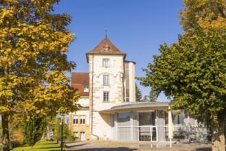 Historic building with tower and autumnal trees under a blue sky, Überlingen, Lake Constance,