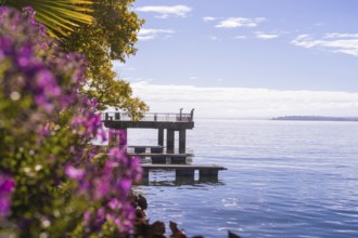 Colourful jetty by the water with flowers in the foreground and calm sky, Überlingen, Lake