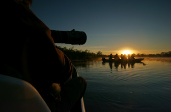 Wildlife photographers in a boat on a river in the Pantanal, Brazil