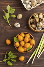 Pile of Smoked Quail eggs in bowl on a brown wooden background. top view, flat lay, close up