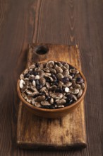 Wooden bowl with Kidney beans on brown wooden background, side view, copy space, minimalism