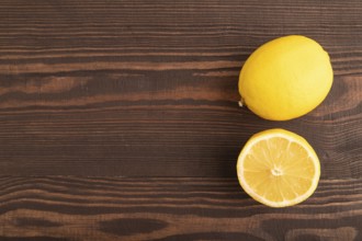 Yellow Lemon Cut in half on brown wooden background. Top view, flat lay, copy space. healthy food,