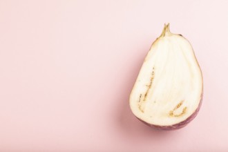 Purple Cutted eggplant with white stripes on pink pastel background. Side view, copy space.