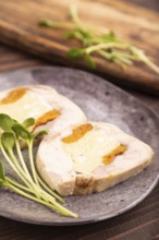 Chicken, egg and dried apricot meatloaf, microgreen on brown wooden. Diet, healthy eating. side