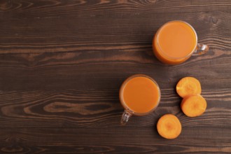 Two glasses with carrot juice, on wooden background. Diet, healthy eating concept. top view, flat