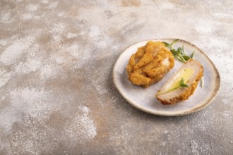 Chicken schnitzel on blue plate with microgreen on brown concrete. Diet, healthy eating. side view,