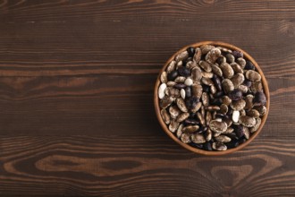 Wooden bowl with Kidney beans on brown wooden background, top view, flat lay, copy space,
