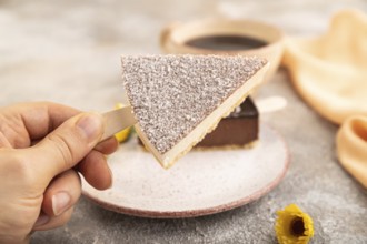 Chocolate and Vanilla Cake pops Marshmallow with hand with cup of coffee on brown concrete