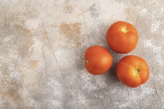 Red tomato on brown concrete background. Top view, flat lay, copy space. healthy food, vegetable,