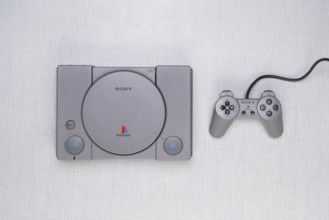 Top shot of a Playstation 1 with controller on a white Resopal board