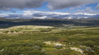 Weite, baumlose Gebirgslandschaft, tiefhängende Wolken und blauer Himmel, Pilgerweg Olavsweg,