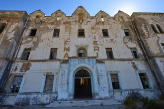 Lost Place, Verfallene Fassade eines Gebäudes mit verblassender Schrift und architektonischen