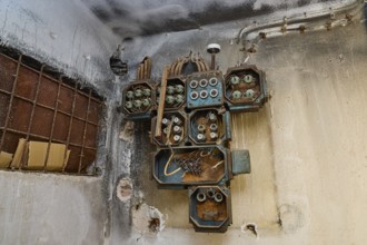 Lost Place, Rostige alte Elektrogeräte an einer verwitterten Wand im Gebäude, Caserma Avieri,