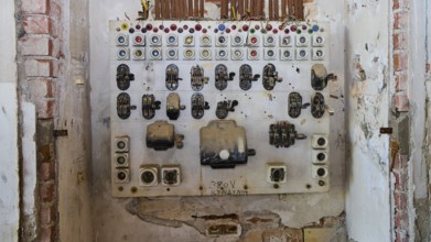 Lost Place, Alte Schalttafel mit bunten Knöpfen in einem verfallenden Raum, Caserma Avieri,