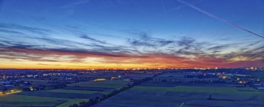 Panorama der Hamburger Vier- und Marschlande bei Nacht. Im Hintergrund die beleuchtete Silhouette
